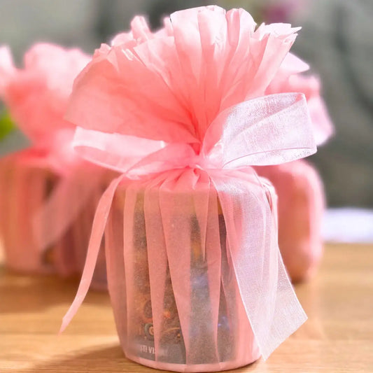 Lumanare impachetat in hartie de matase de culoare roz, si prinsa cu o panglica.