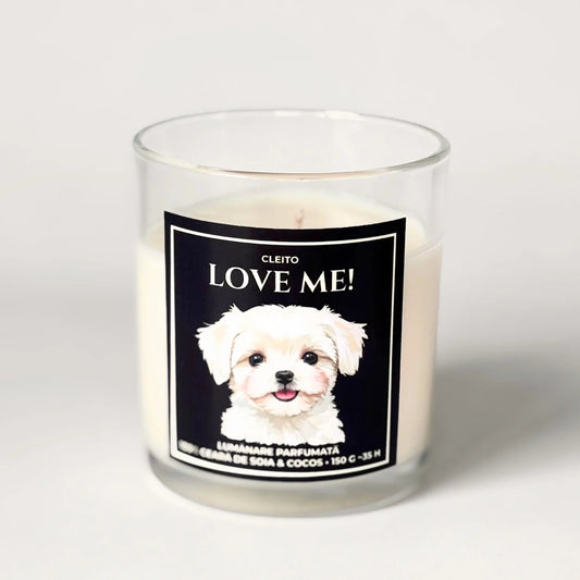 Lumânare artizanală Cleito din ceară de soia și cocos în pahar de sticlă transparentă, cu etichetă neagră premium. Eticheta prezintă o ilustrație adorabilă a unui cățel Bichon Maltese și textul alb „Cleito LOVE ME!”.