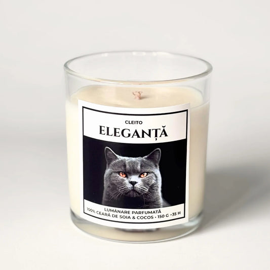 Lumanare parfumata artizanala Cleito in recipient de sticla, cu eticheta alba ce contine o fotografie cu o pisica British Shorthair mândră cu ochi aurii și mesajul 'ELEGANȚĂ'. Ceară de soia și cocos turnata manual.